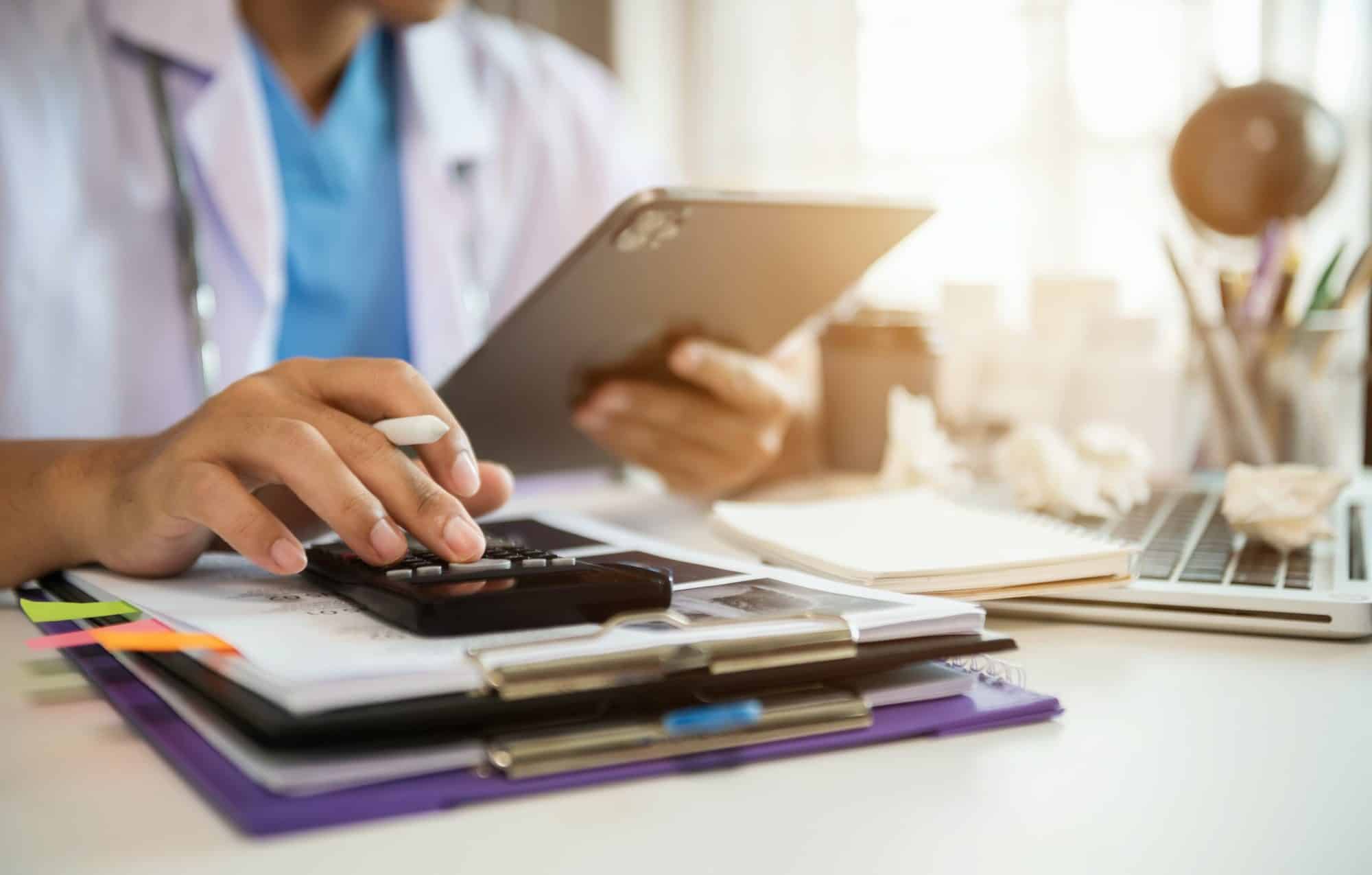 Doctors use a service fee calculator to save money on health insurance, drug cost concepts.