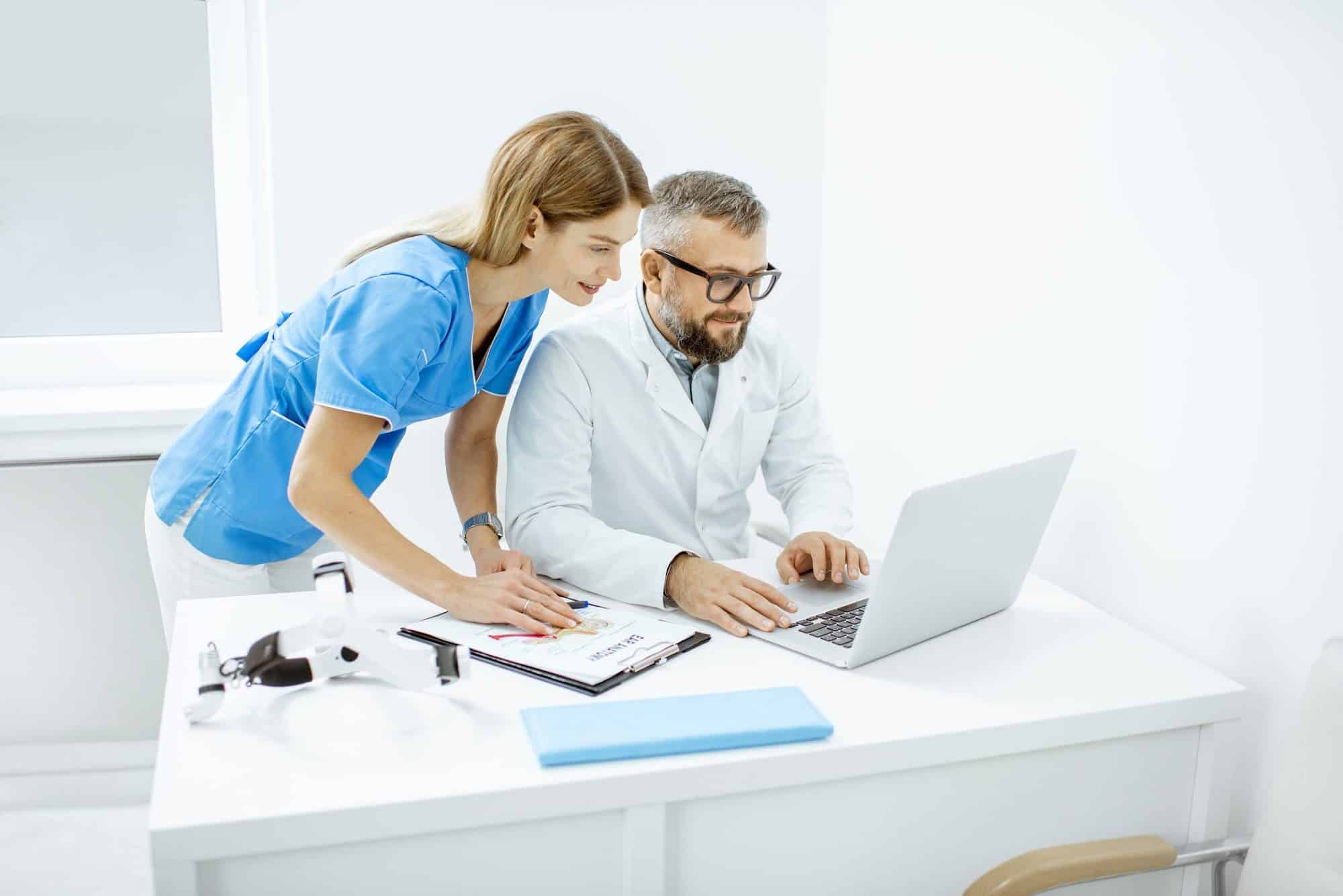 Two doctors working with laptop in the office