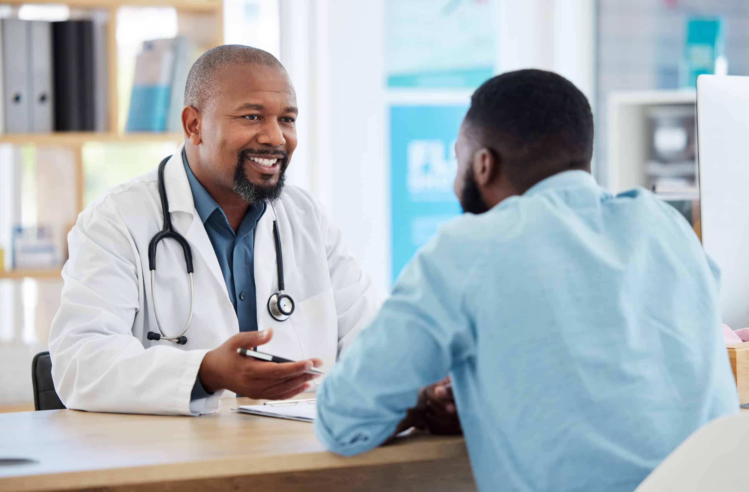 Medical physician talking to his patient. African american patient in a checkup with his doctor. Co
